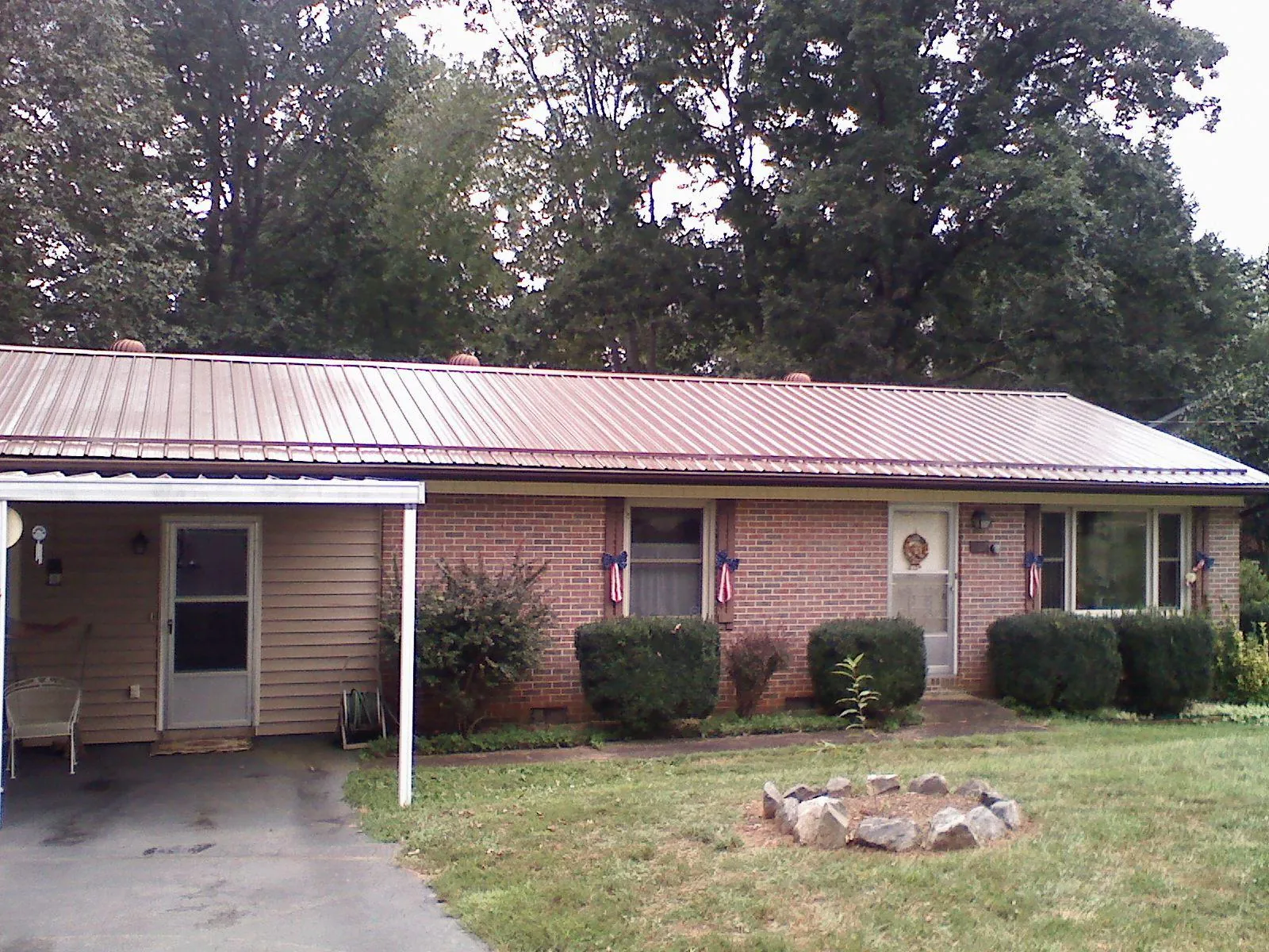 Bronze metal roof and carport on a brick ranch home — Roof Repair work by our crew in Rubicon